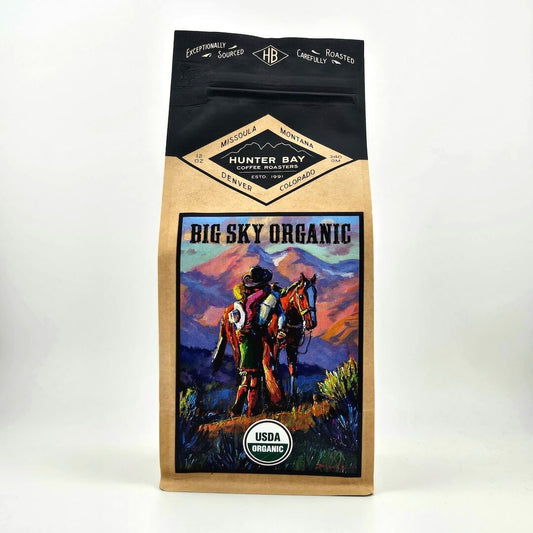 Coffee bag with 'Big Sky Organic' design featuring a person on horseback against a mountainous landscape.