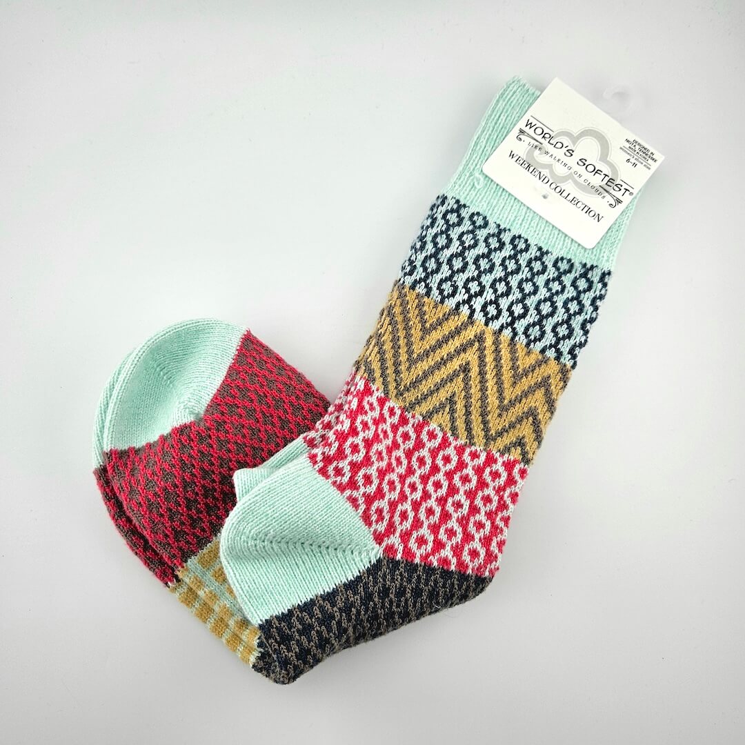 Colorful patterned socks with a 'World's Softest' tag on a light gray background