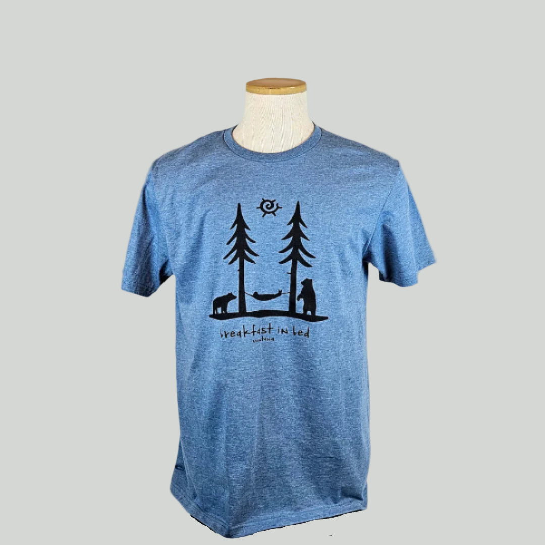 Blue t-shirt with black tree & hammock graphic design on a mannequin against a white background