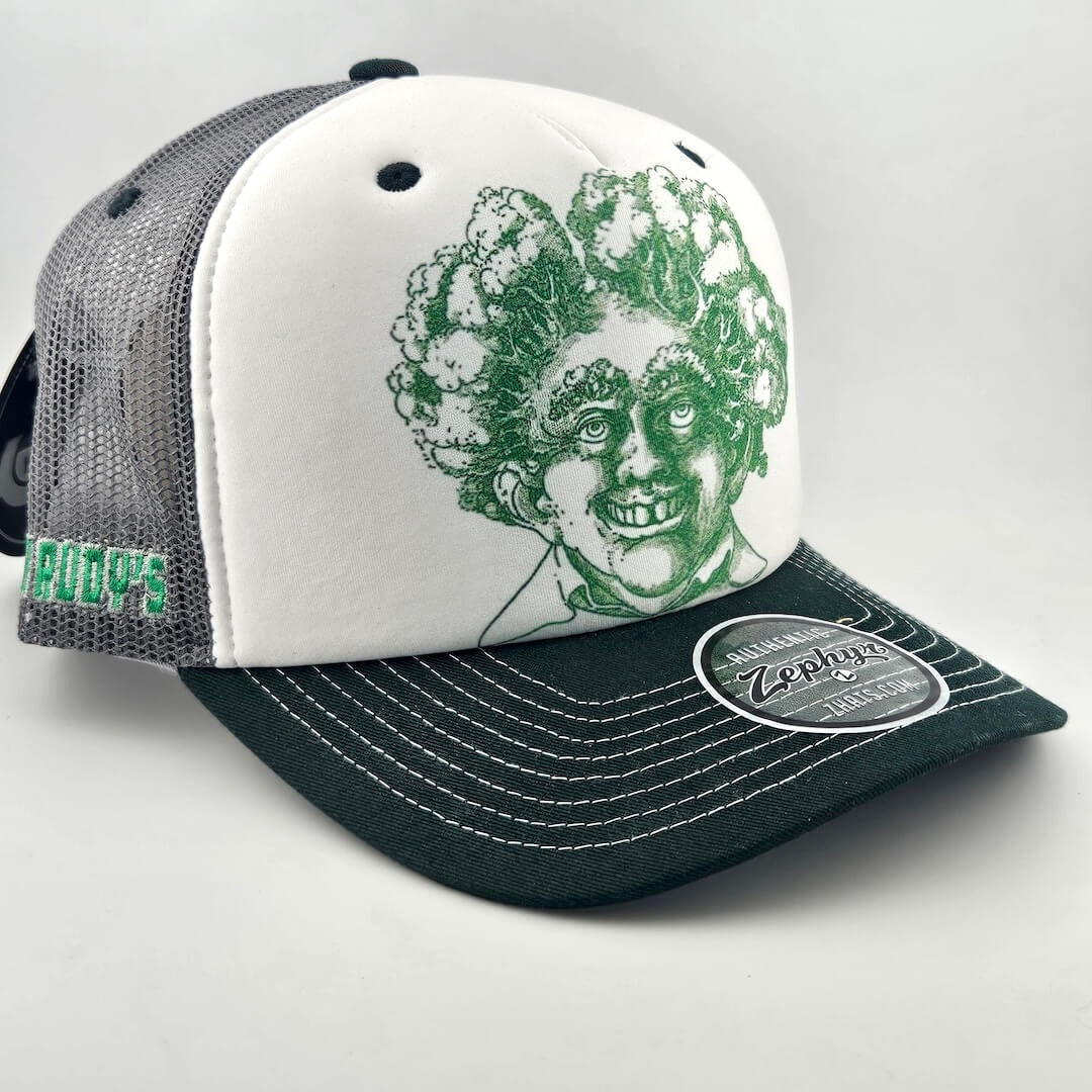 White face trucker hat with green mesh & bill featuring green stamp looking smiling man's head with trees for hair. 