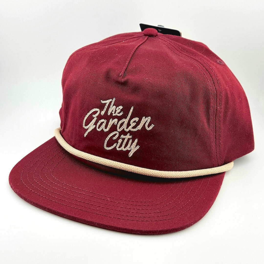 Red cap with 'The Garden City' text on a white background