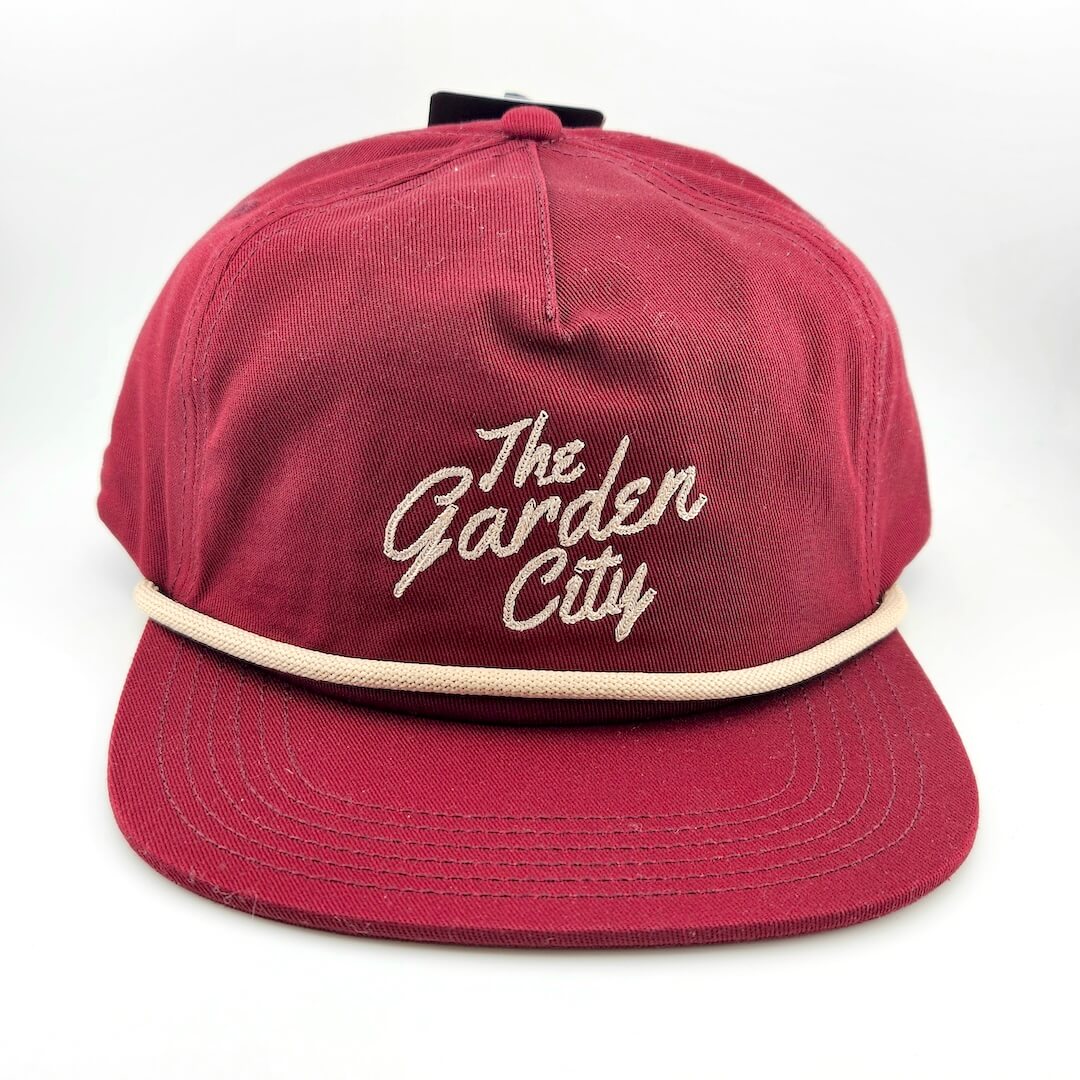 Red cap with 'The Garden City' text on a white background