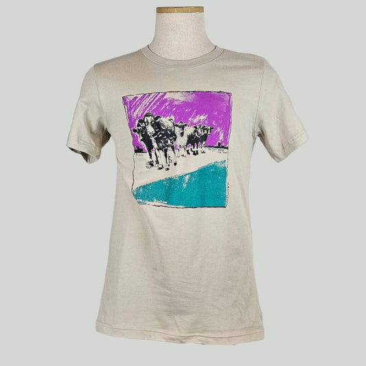 Sand colored shirt with central square half purple, 1/4 white, 1/4 blue with group of cows in center, all looks hand painted
