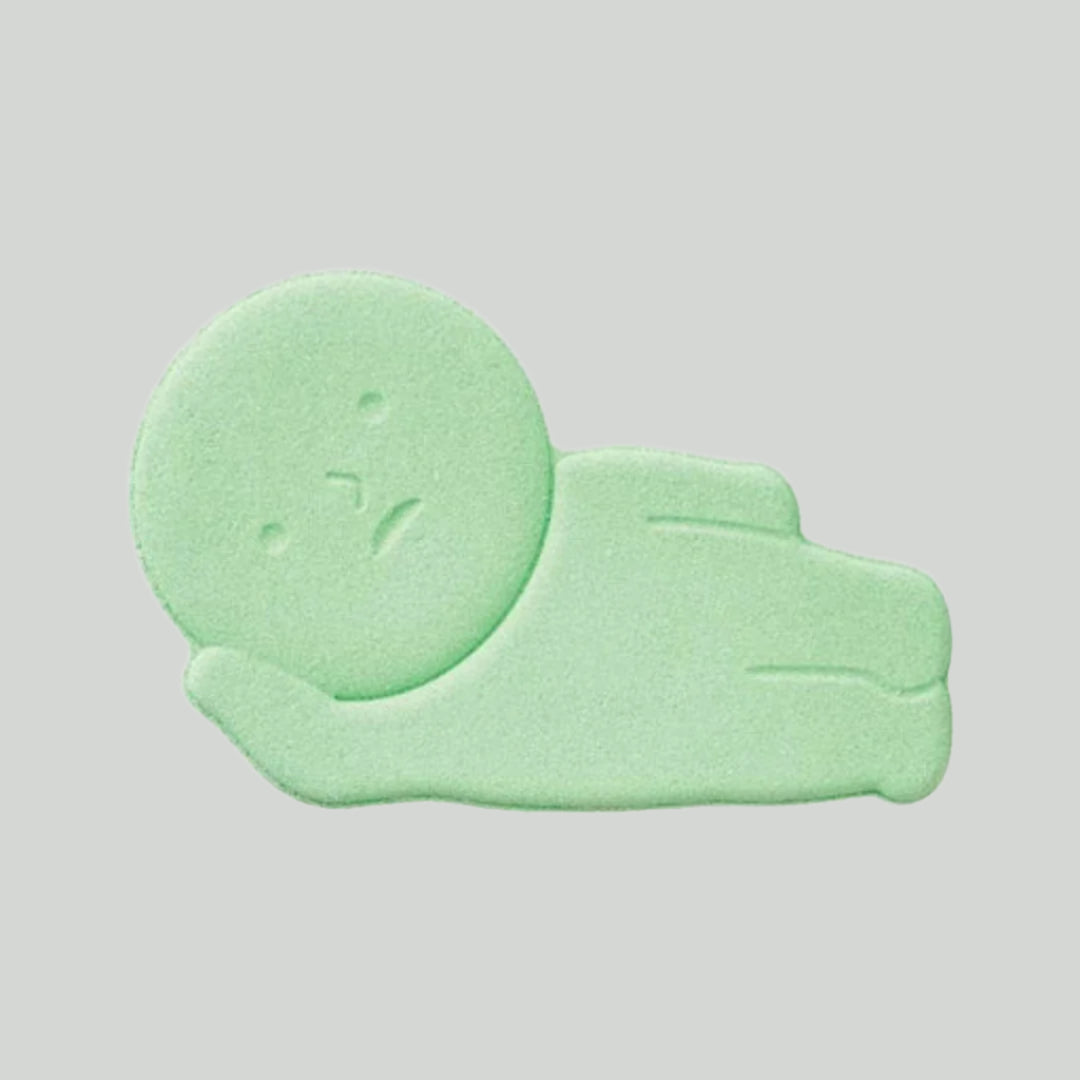 Seafoam green bath product shaped like human laying down with head propped up on hand.
