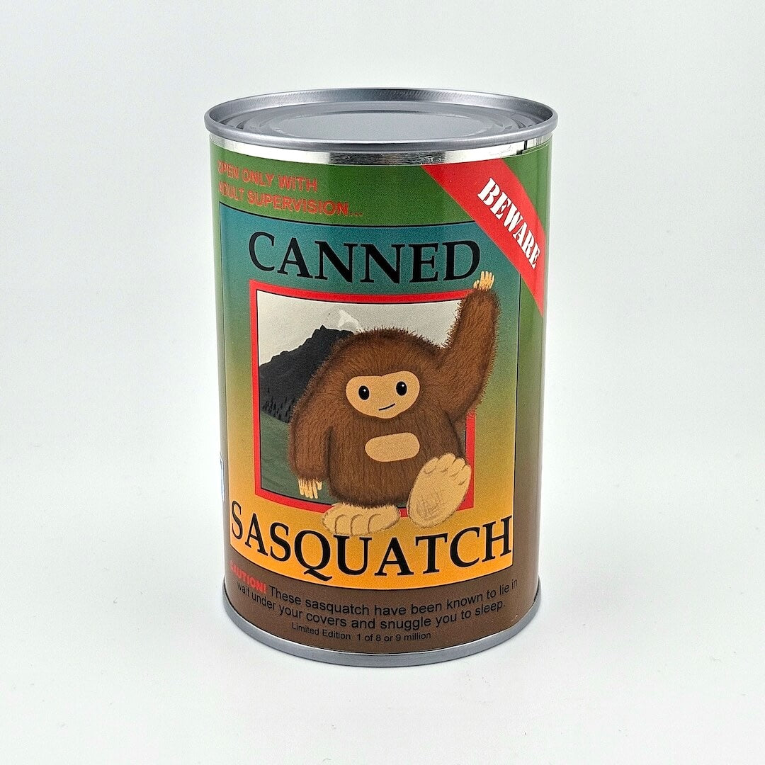Can with colored label with black print title, simplified image of Sasquatch in center. 