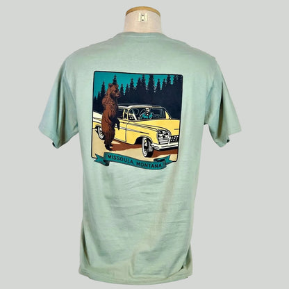 Light green t-shirt with a graphic of a bear and a car on a mannequin against a white background