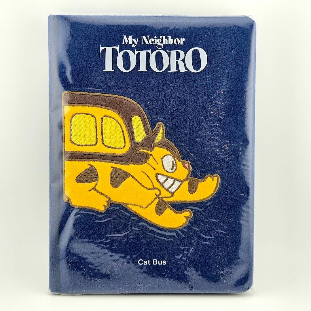 Notebook with a cartoon cat bus on a blue background, featuring 'My Neighbor Totoro' text.