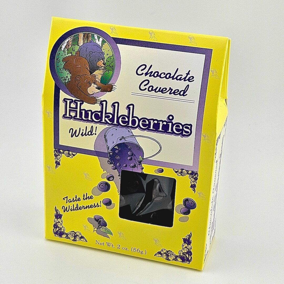 Yellow packaging of chocolate-covered huckleberries with a bear illustration on a white background