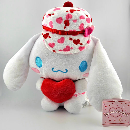 White plush toy with red heart and patterned hat on a gray background
