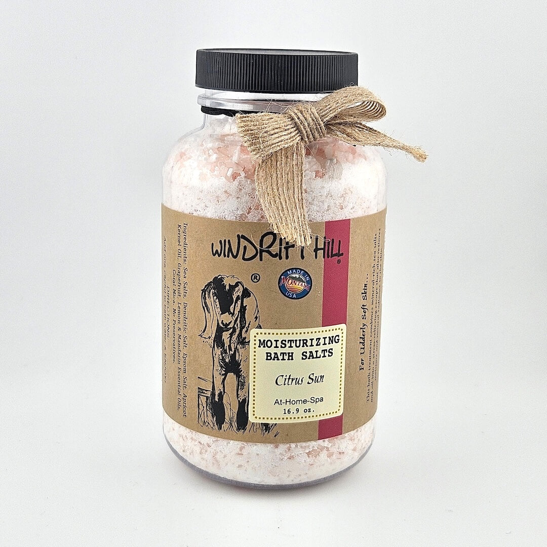 Jar of Windrift Hill bath salts with a decorative ribbon on a gray background