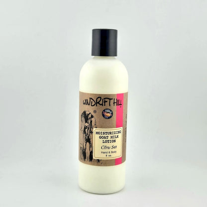 Plastic bottle of Windrift Hill moisturizing goat milk lotion on a gray background