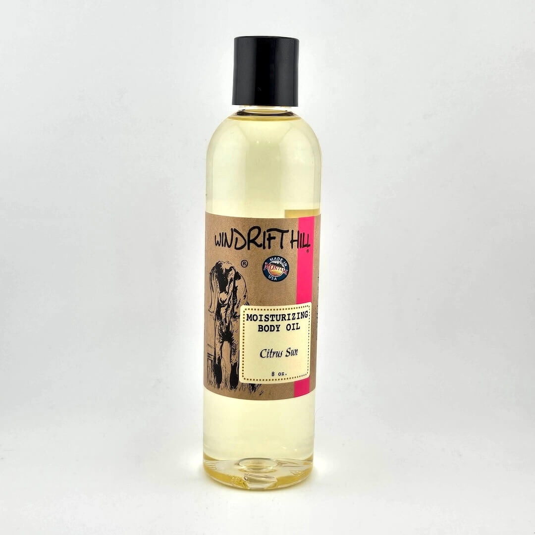 Plastic bottle of Windrift Hill moisturizing body oil on a gray background