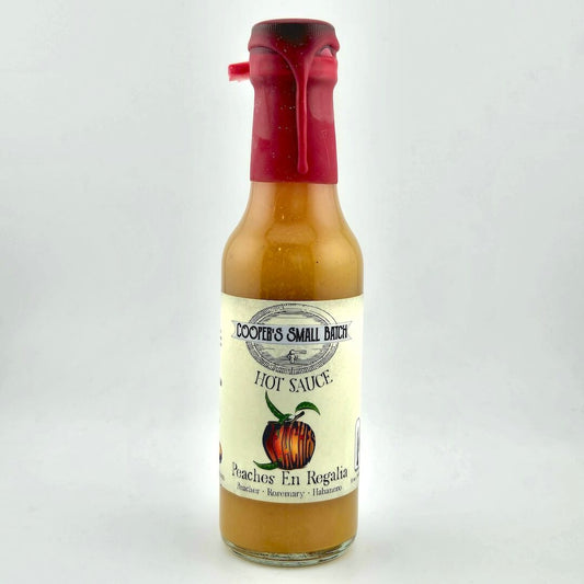 Bottle of Cooper's Small Batch Hot Sauce with a red cap on a white background