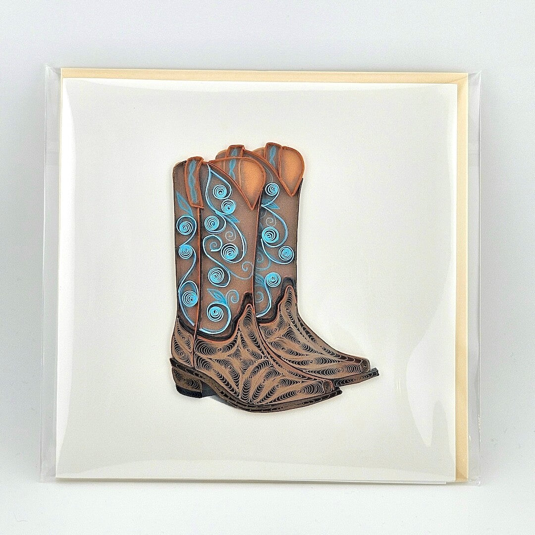 Quilled artwork of brown cowboy boots with blue patterns on a white background