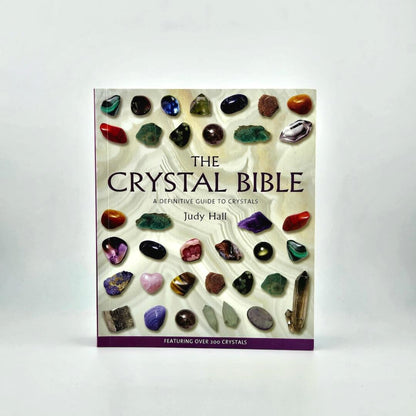 Book titled 'The Crystal Bible' by Judy Hall with images of crystals on a white background