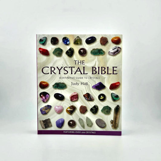 Book titled 'The Crystal Bible' by Judy Hall with images of crystals on a white background
