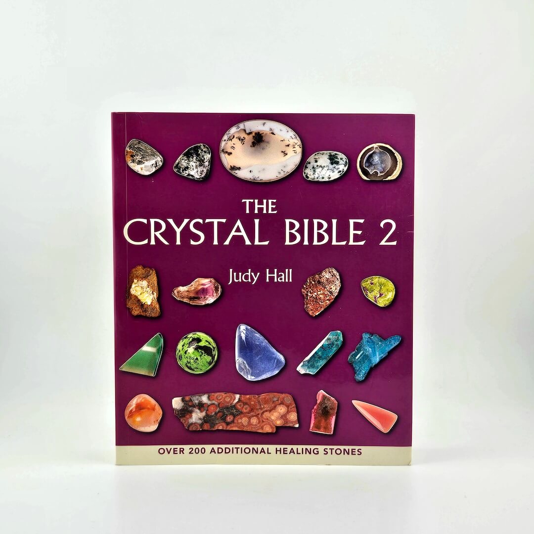Book titled 'The Crystal Bible 2' by Judy Hall with images of crystals on a purple background.