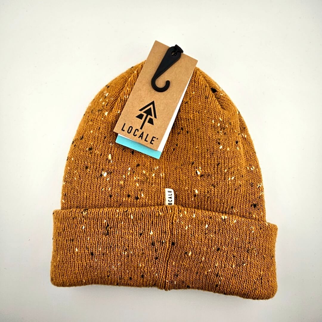 Brown beanie with speckled pattern and 'Locale' tag on a white background