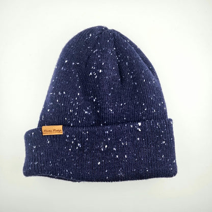 Navy blue speckled beanie with a brand label on a white background