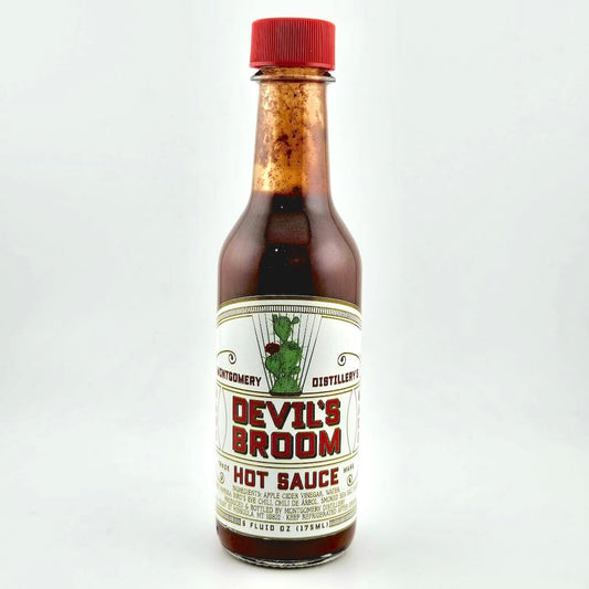 Bottle of Devil's Broom hot sauce with a red cap on a white background