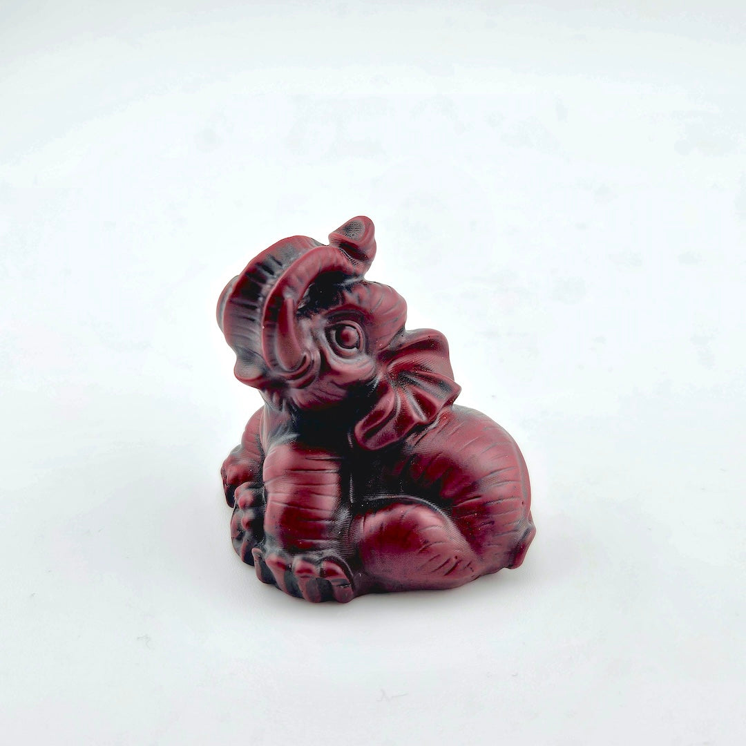 Red elephant figurine on a white background