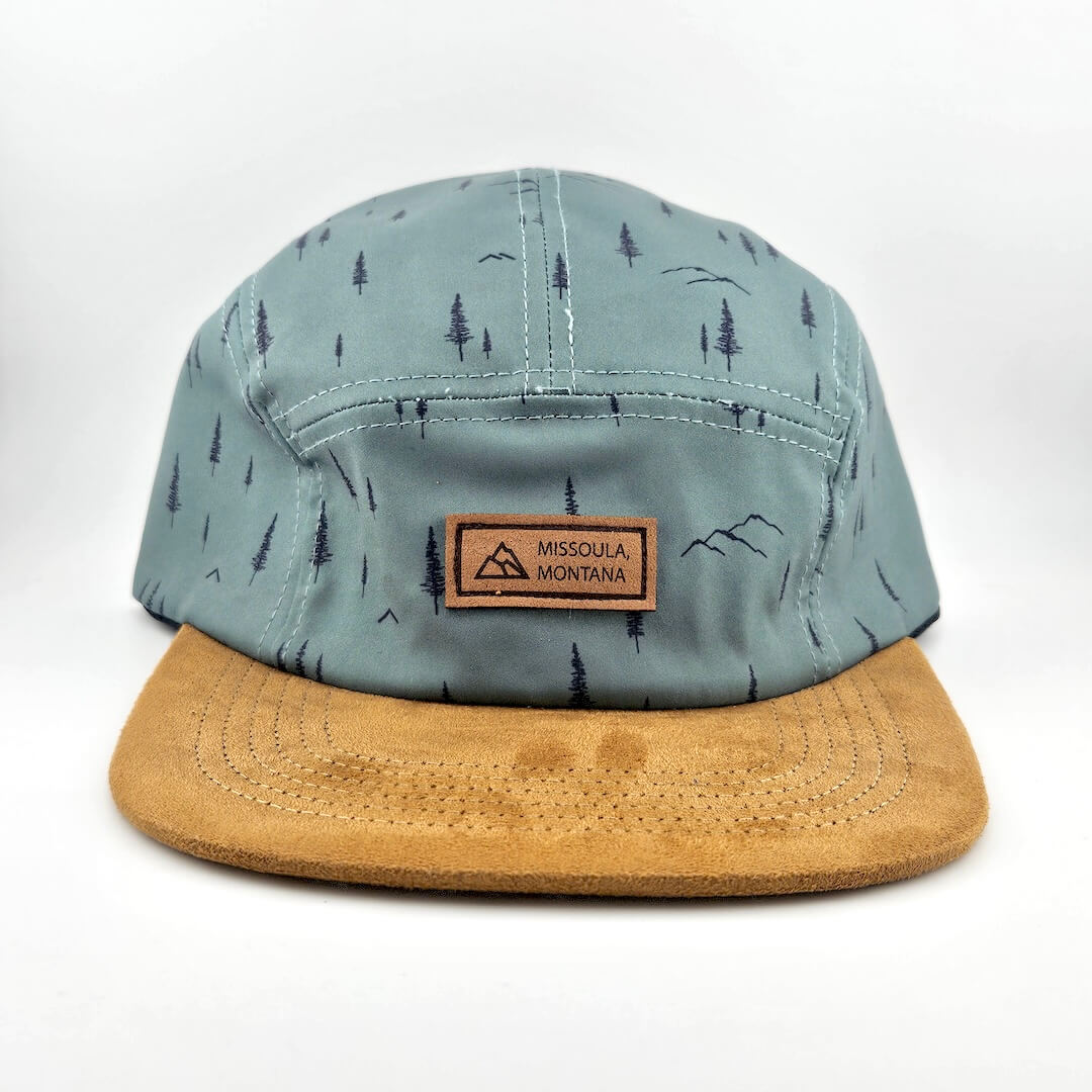 Cap with tree pattern and brown brim on a white background