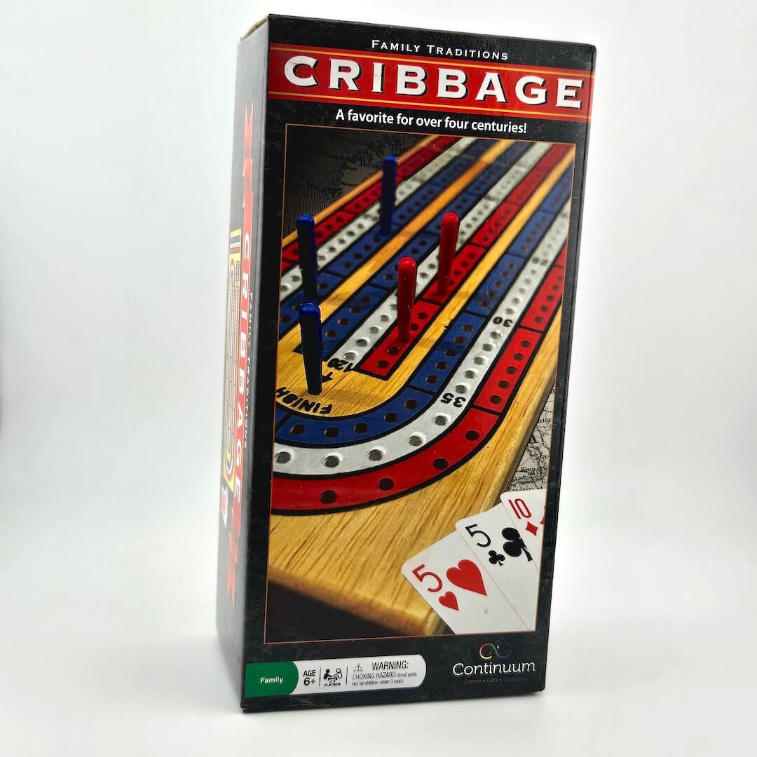 Cribbage board game box with playing cards on a white background
