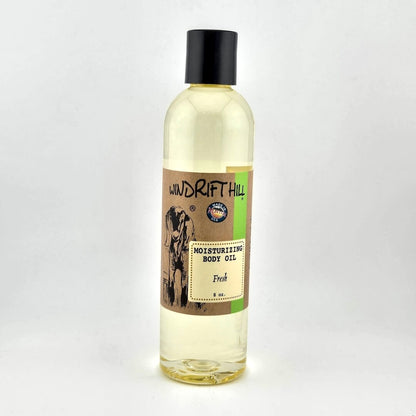 Plastic bottle of Windrift Hill moisturizing body oil on a gray background