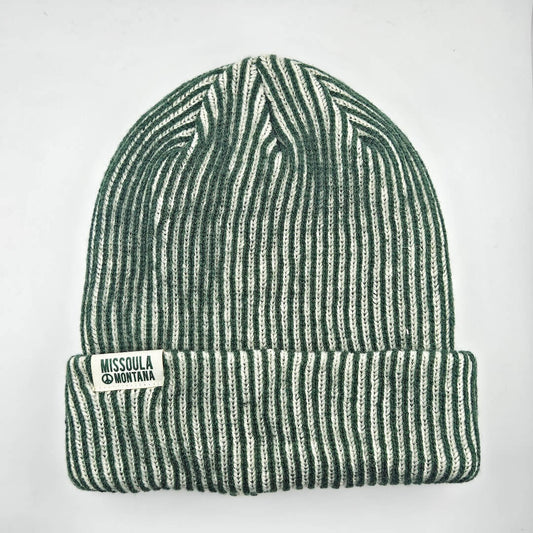 Green and white striped beanie with a label on a light gray background