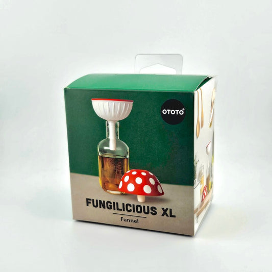Green packaging with red and white spotted funnel shaped like a mushroom. 