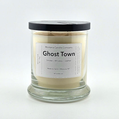 Glass jarred candle with black lid, label with printed company name top, scent name in center, then listed scent components.