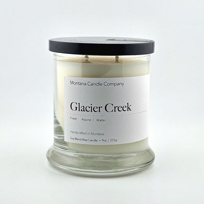 Glass jarred candle with black lid, label with printed company name top, scent name in center, then listed scent components.