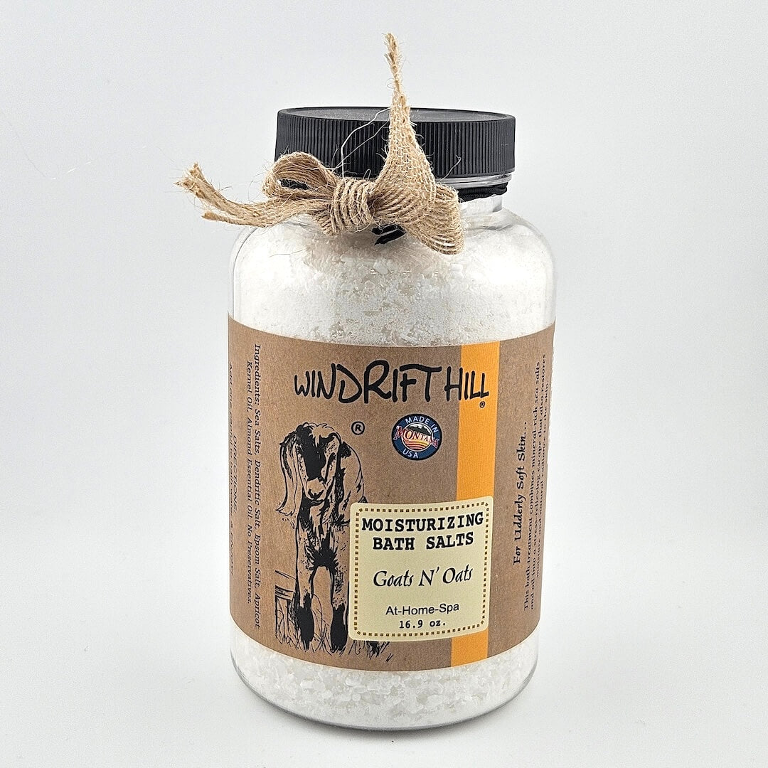 Jar of Windrift Hill bath salts with a decorative ribbon on a gray background