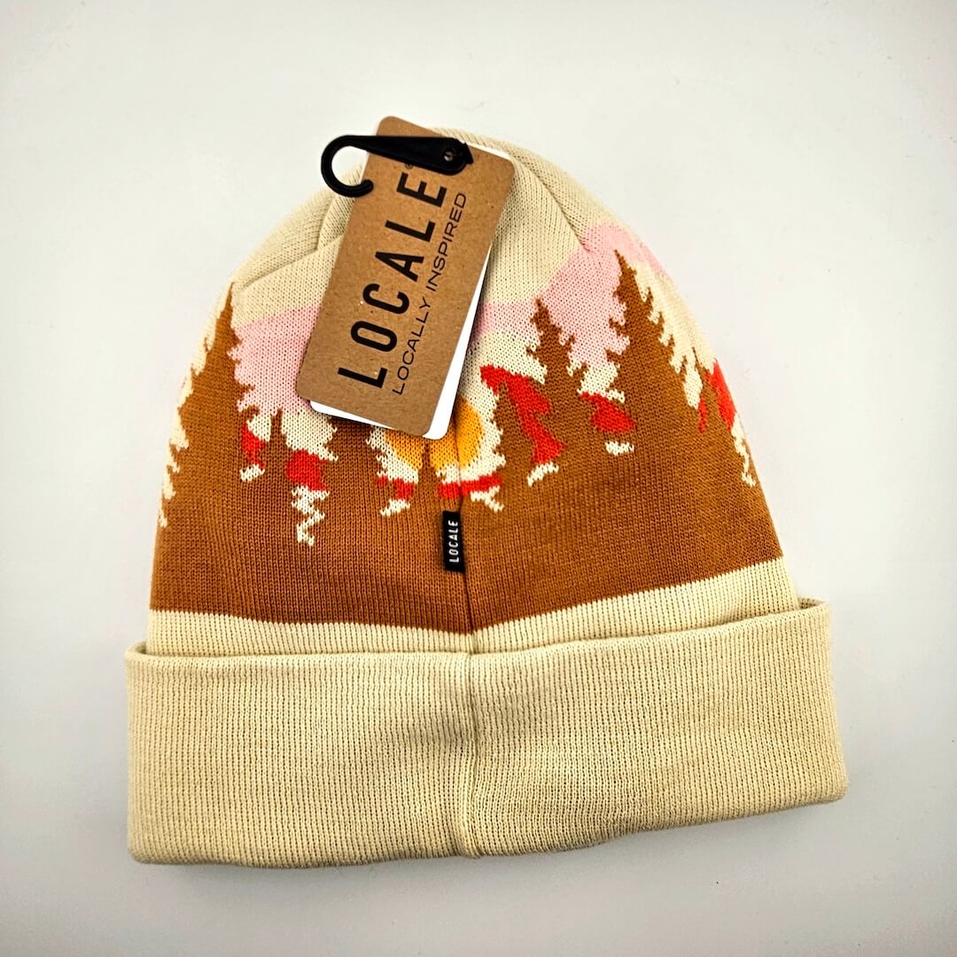 Beige and brown beanie with tree line pattern and 'Locale' tag on a light gray background