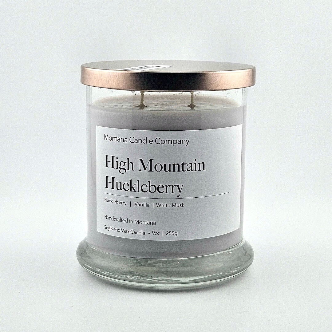 Glass jarred candle with copper lid, label with printed company name top, scent name in center, then listed scent components.