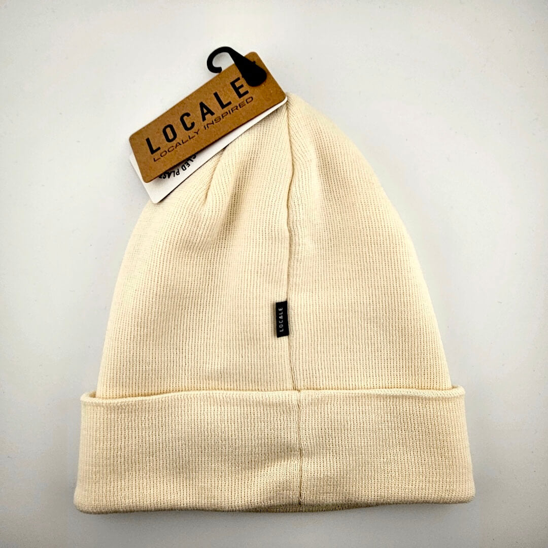 Beige beanie with a visible brand tag on a light gray background