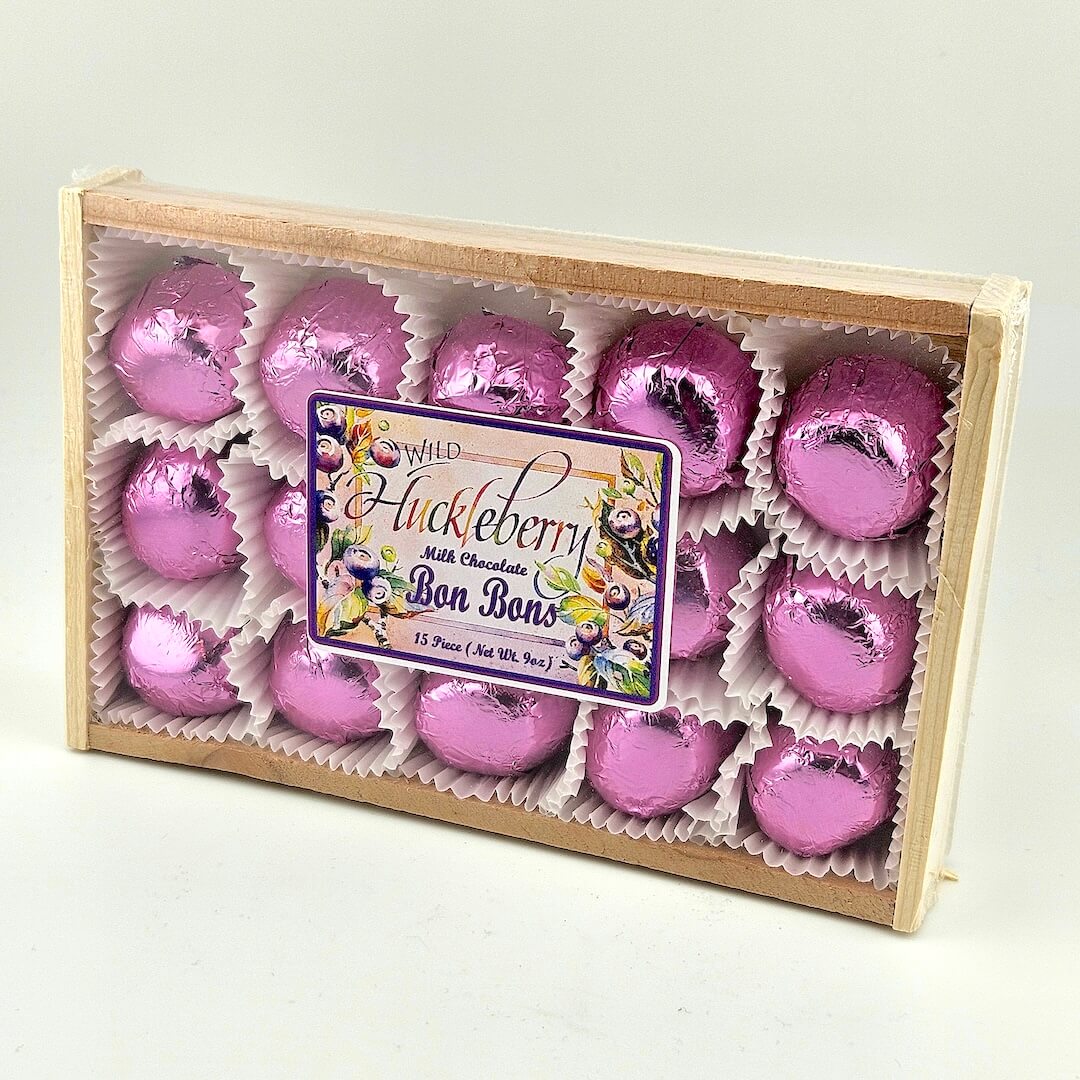 Box of pink chocolate bonbons with a visible label on a light gray background