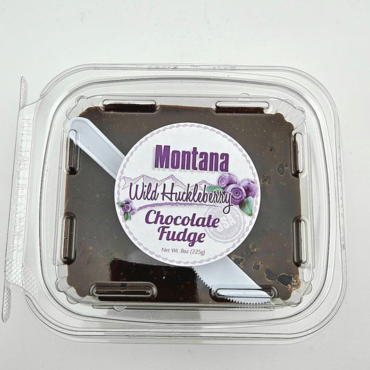 Container of Montana Wild Huckleberry Chocolate Fudge with a clear lid on a white background