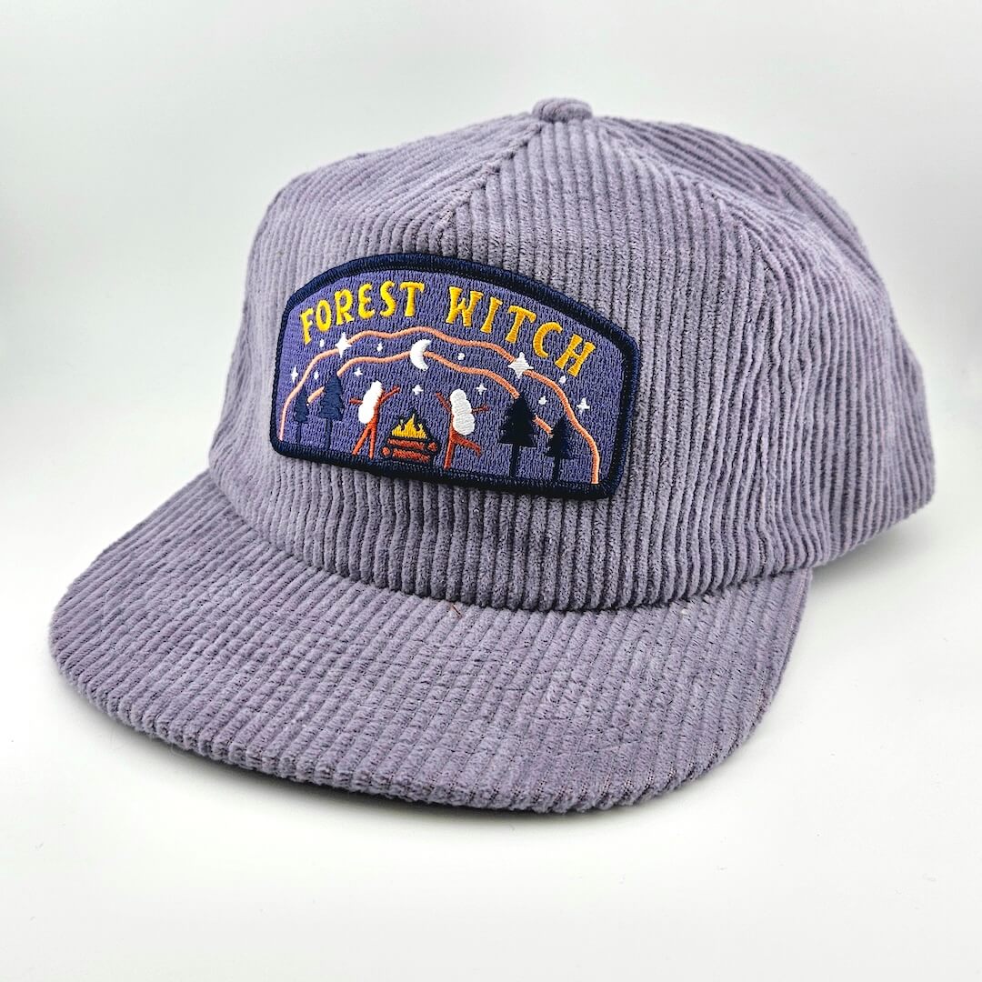 Purple corduroy cap with 'Forest Witch' patch on a white background
