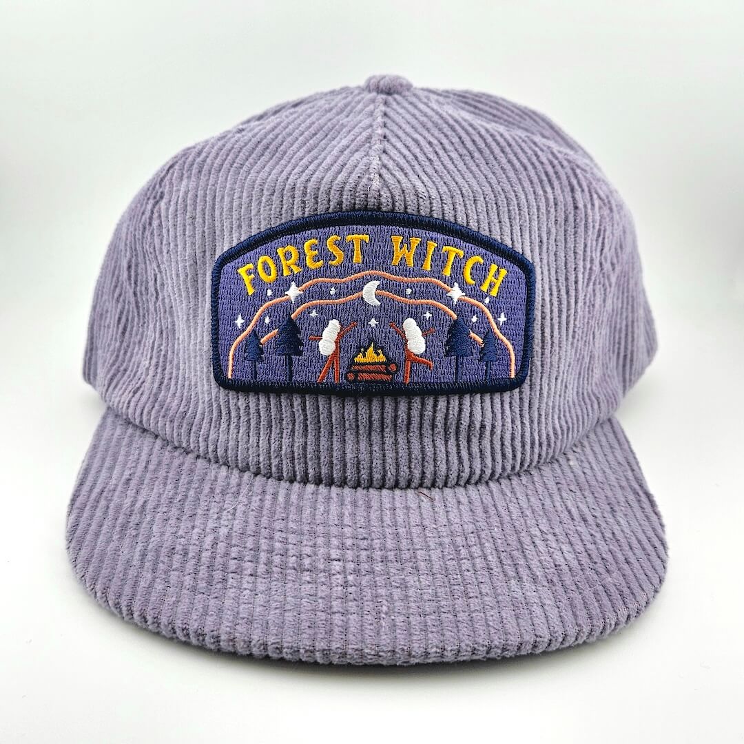 Purple corduroy cap with 'Forest Witch' patch on a white background