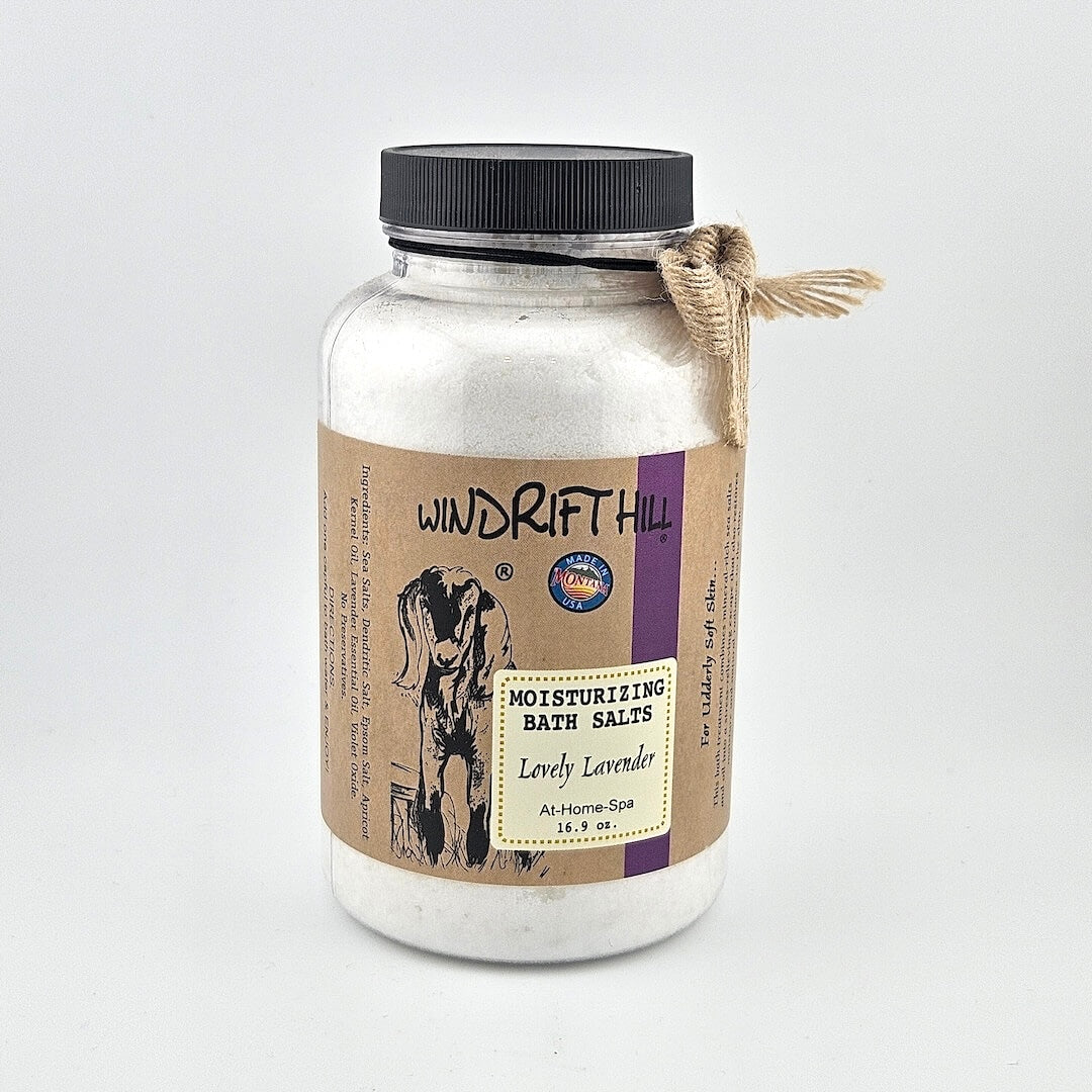Jar of Windrift Hill bath salts with a decorative ribbon on a gray background