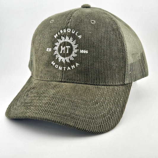 Green corduroy had with circular sunburst in center with "MISSOULA, MONTANA" encircling it with "MT" in center of sun.