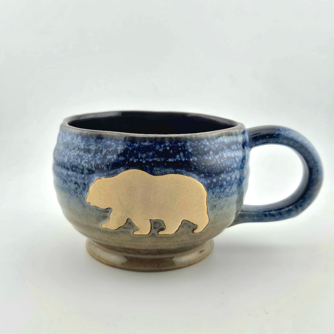 Blue speckled mug with a bear silhouette on a white background