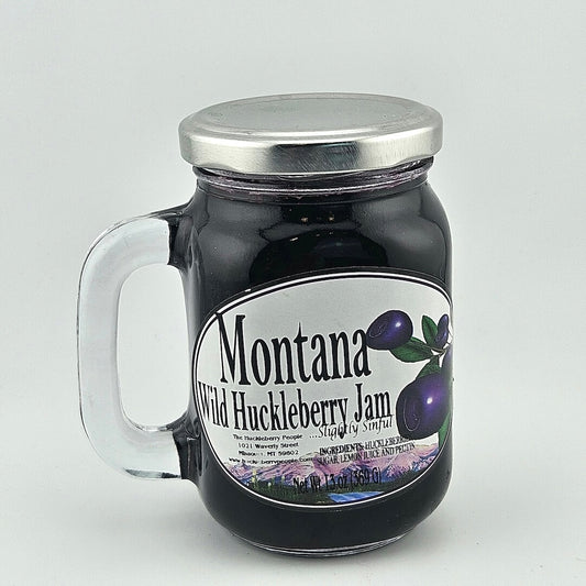 glass jar with handle and silver lid with label detailing product info in black print next enlarged huckleberry image. 