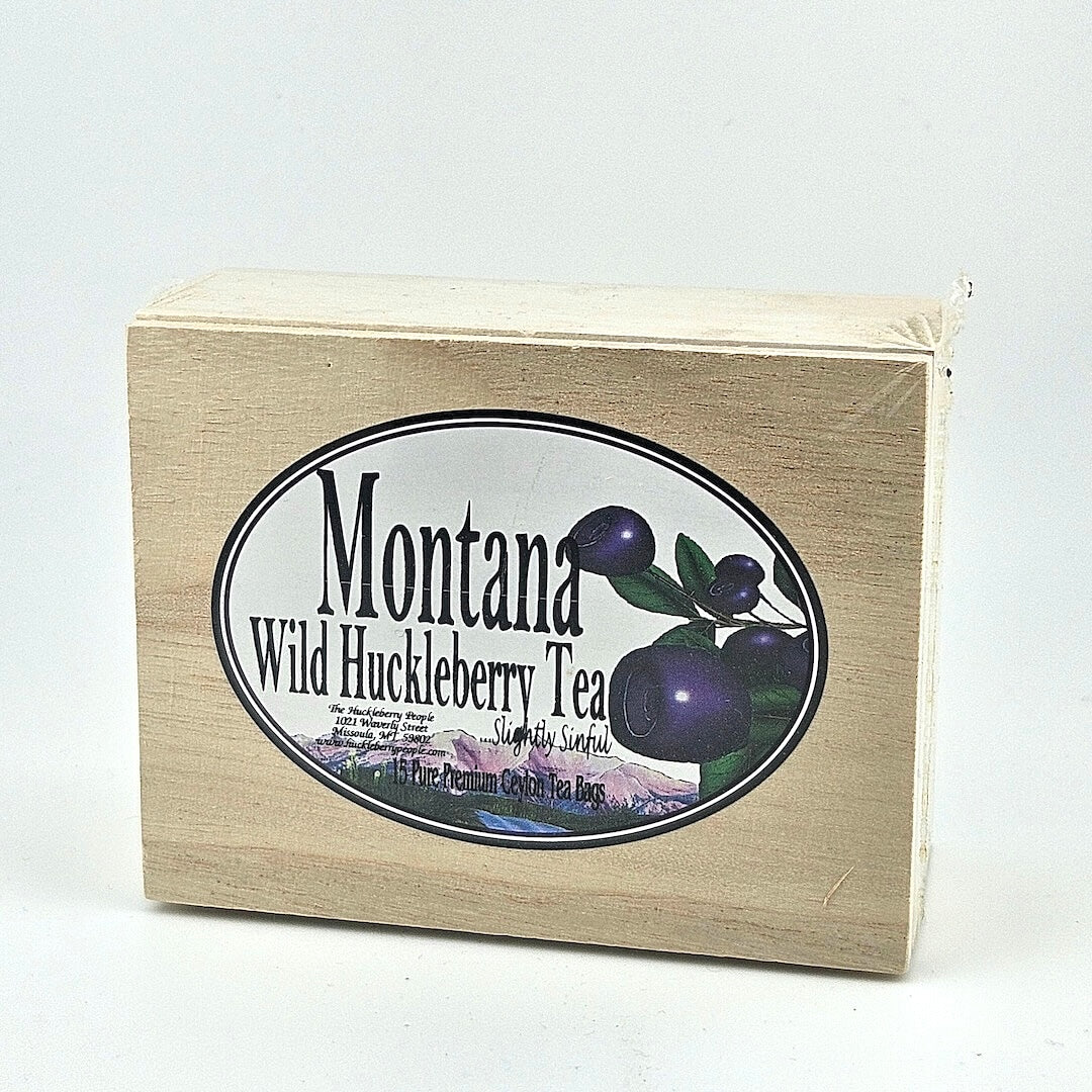 Plastic sealed wooden box with oval white label in center. Label has enlarged huckleberries image to right of product info.