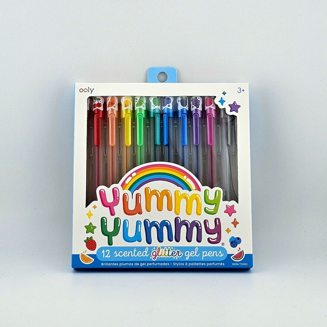 Package of scented glitter gel pens with "Yummy Yummy" branding, pens in rainbow order in window. 