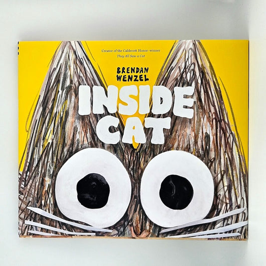 yellow hardcover book titled "Inside Cat" by Brendan Wenzel against white background.