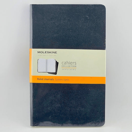 Moleskine notebook with a black cover and orange band on a light gray background