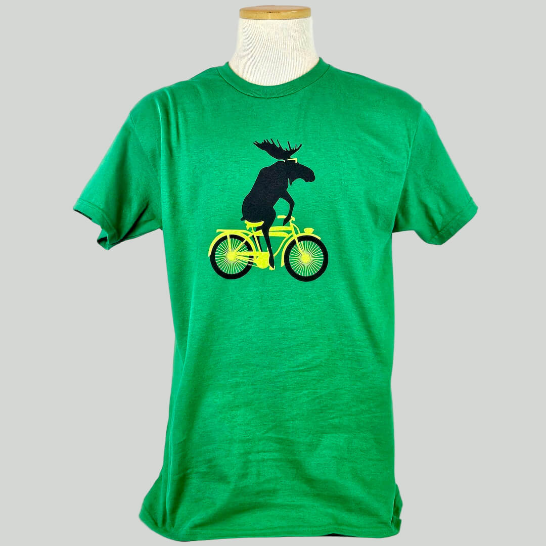 Green t-shirt with a moose riding a bicycle graphic on a mannequin against a white background