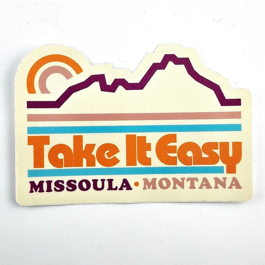 Sticker with 'Take It Easy Missoula Montana' text and mountain design on a white background
